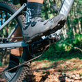 Person wearing cycling shoes is stepping on the Funn Tactic pedal with a forest background.