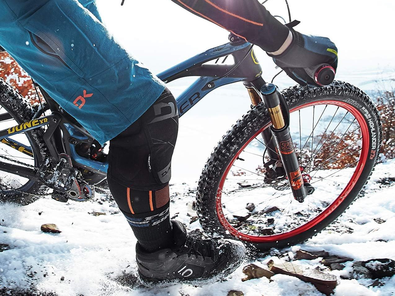 a rider is riding on snowy trail with his mountain bike equipped with grey funn combat iii lock on bike grips