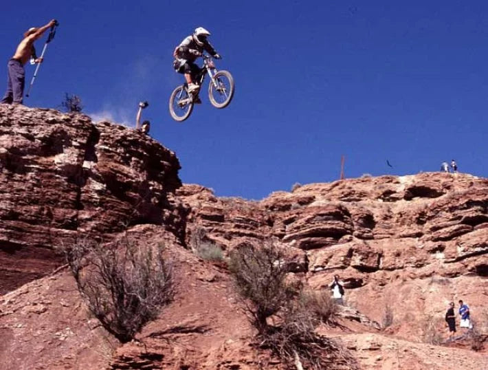 a man riding a bike jumping off the cliff