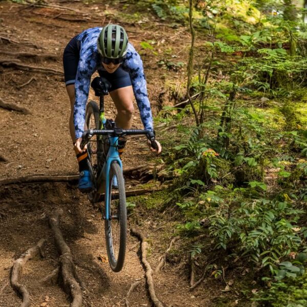 a rider riding down the hill with a gravel bike