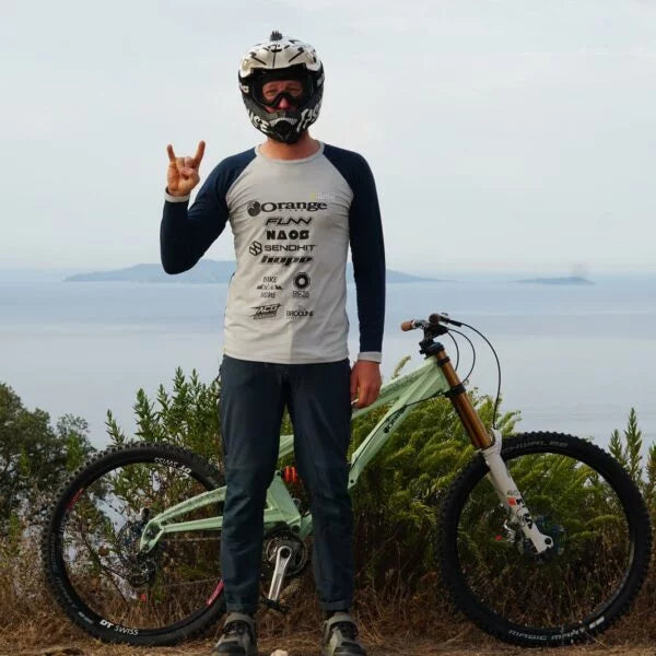 a male mountain bike rider with jerssery and a bike in the background