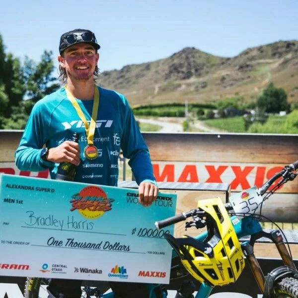 a mountain bike rider holding a board with one thousand dollar written on it.