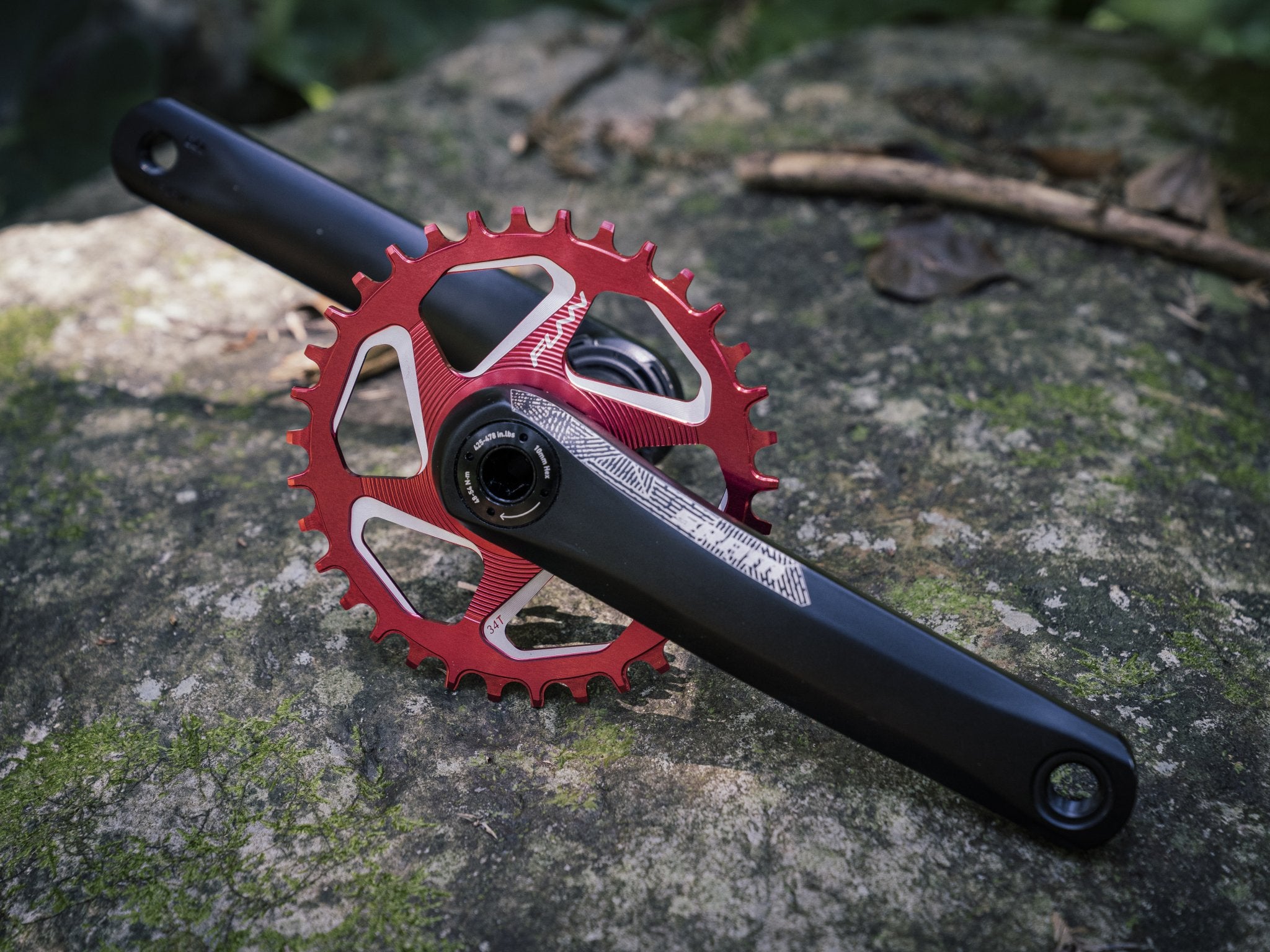 This image displays a crankset featuring a red funn solo dx chainring, placed against a rocky, natural backdrop.