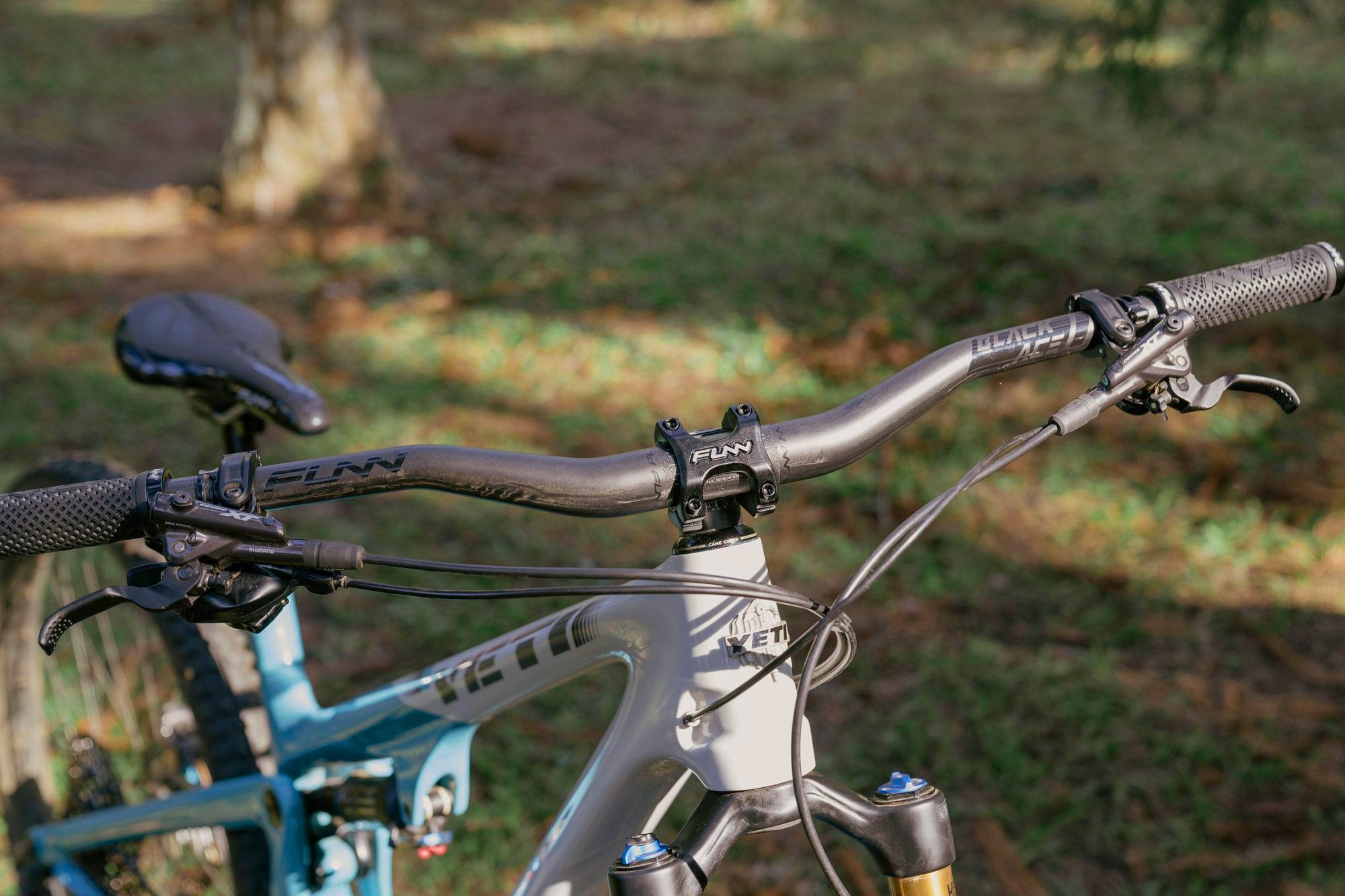 The front angle of a mountain bike equipped with funn black ace handlebar and crossfire bike stem in black