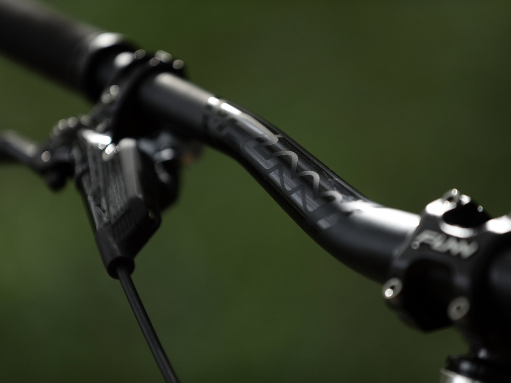 a close up of detail on the surface of a black funn kingpin bike handlebar