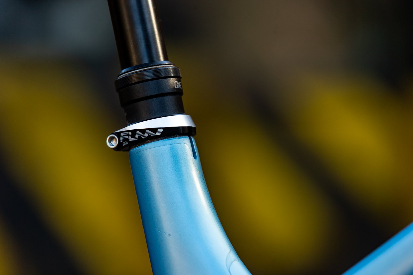 a close-up view of a funn frodon seat clamp on a mountain bike in a blurry outdoor background.