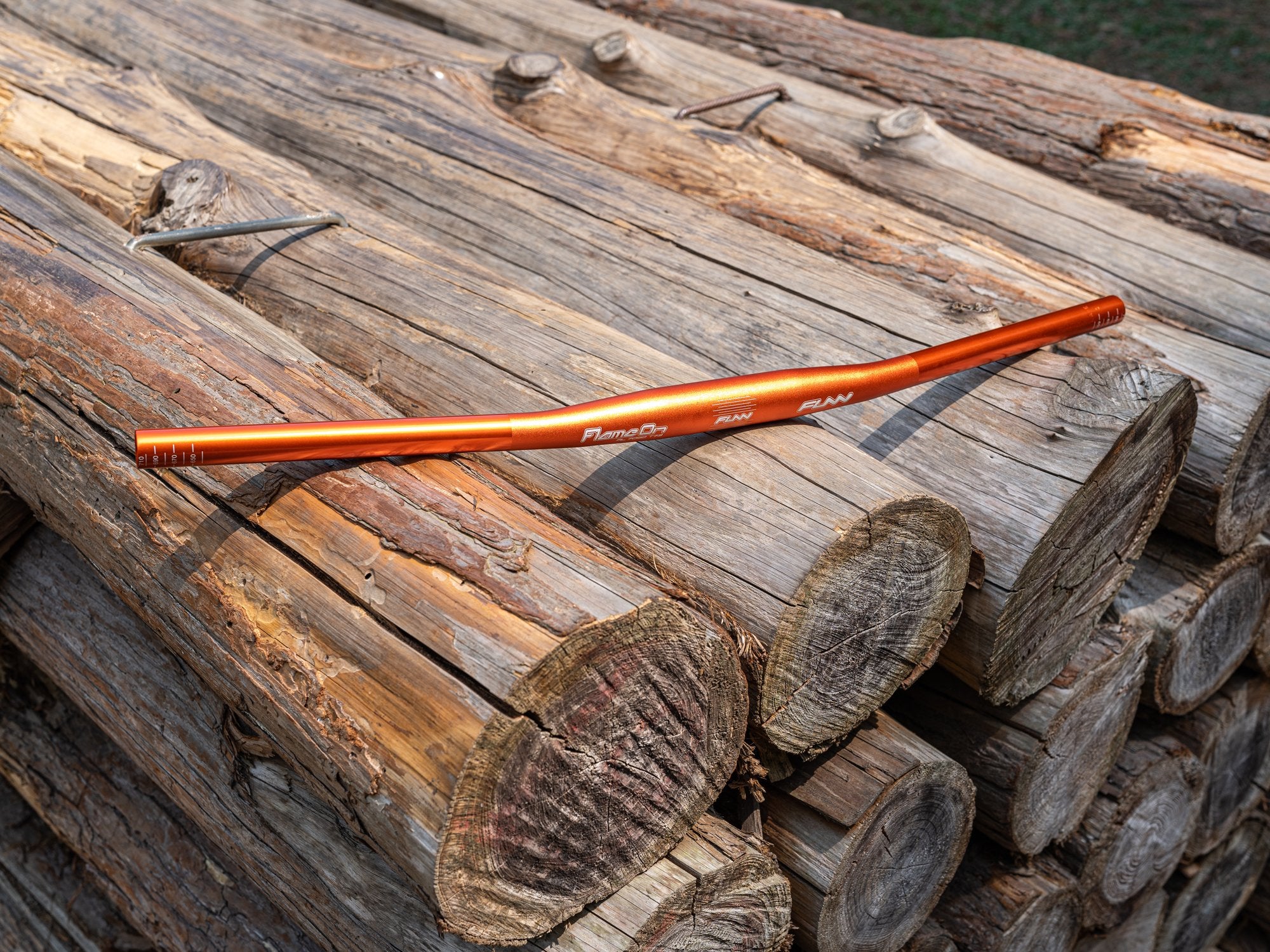 a orange funn flame on flat bicycle handlebar on the chopped wood