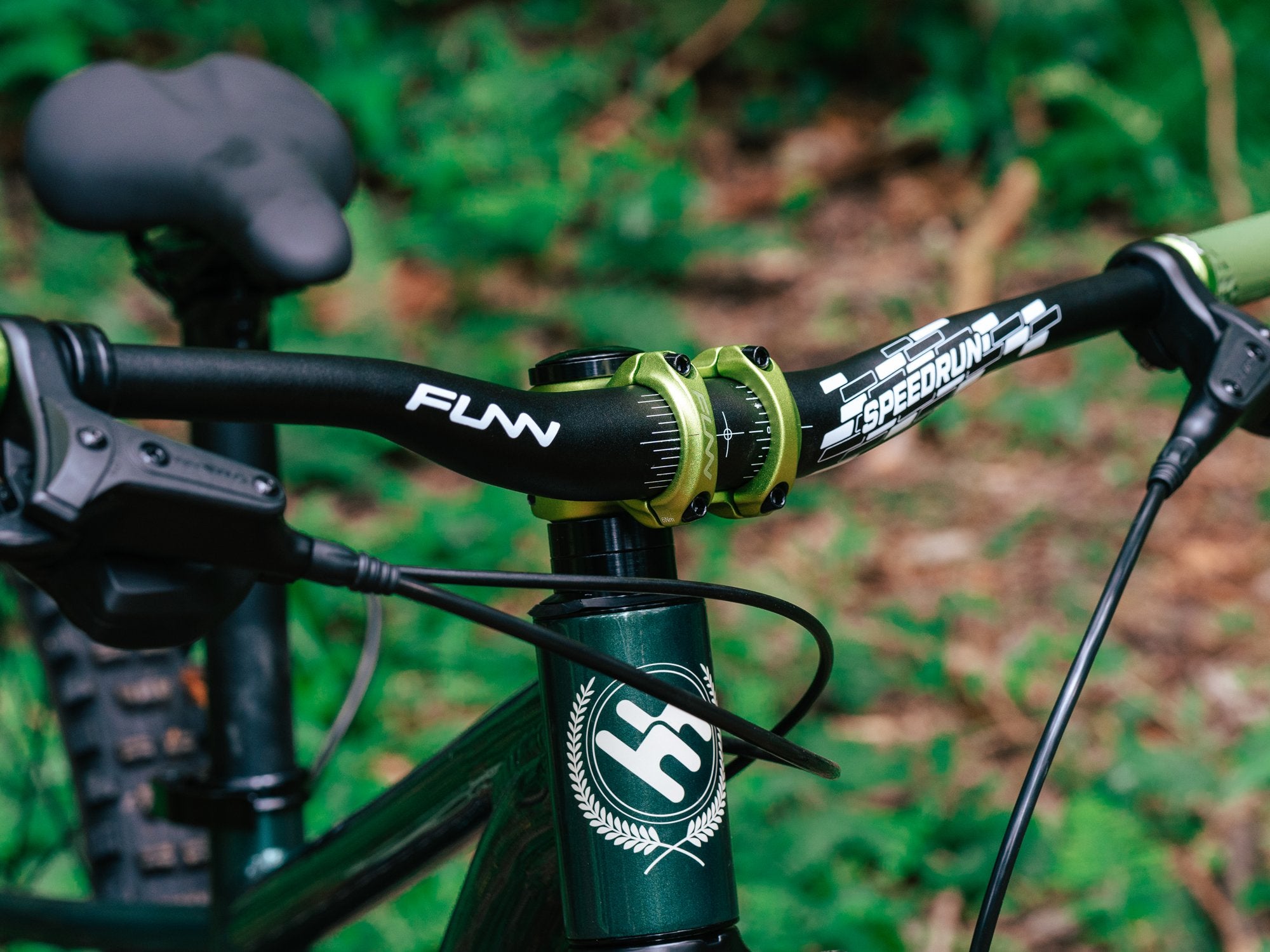 the front side of a mountain bike equipped with a black funn speedrun bike handlebar and a green nixie bike stem