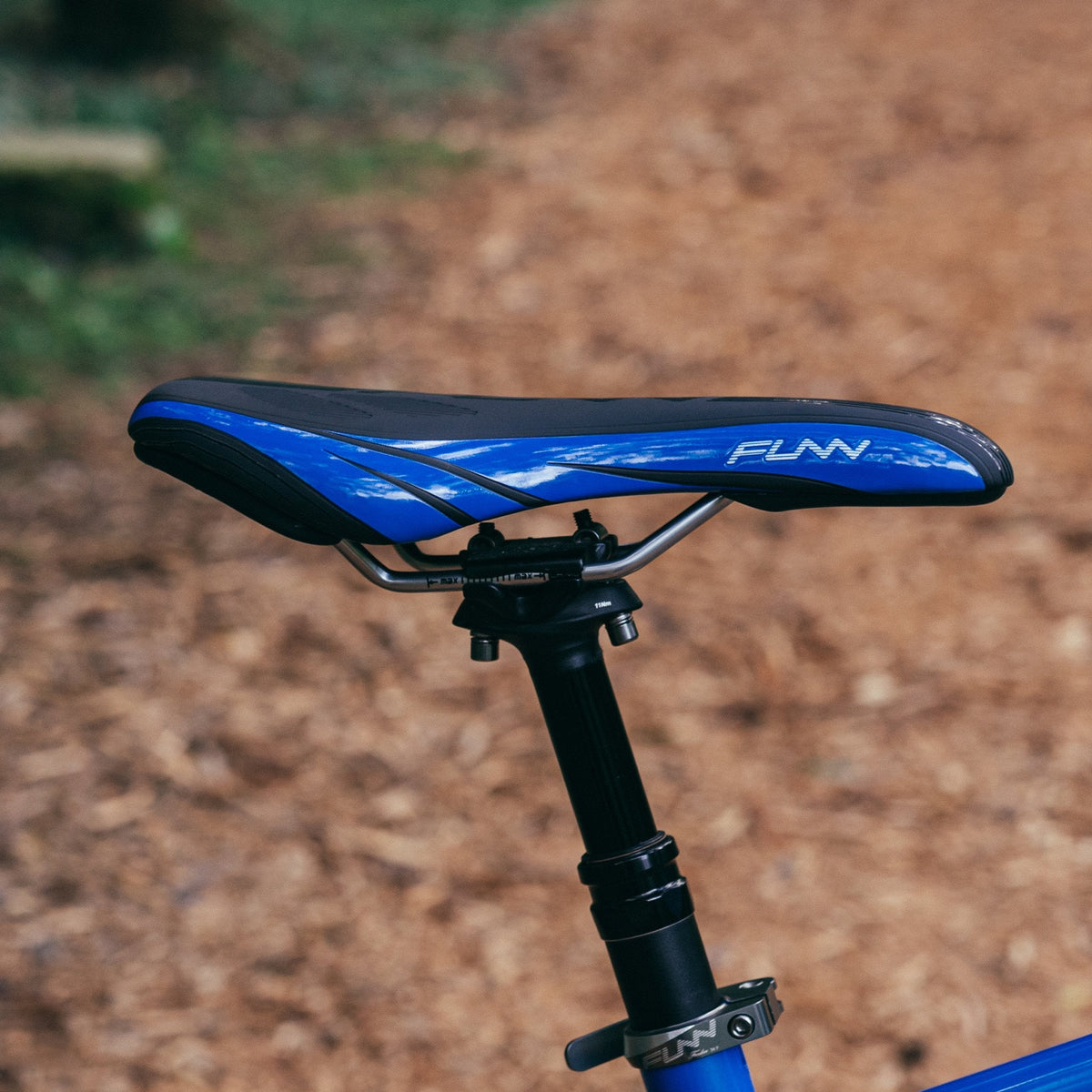 FUNN Adlib HD Saddle with blue-black slim profile and durable CrMo rails mounted on a mountain bike seatpost
