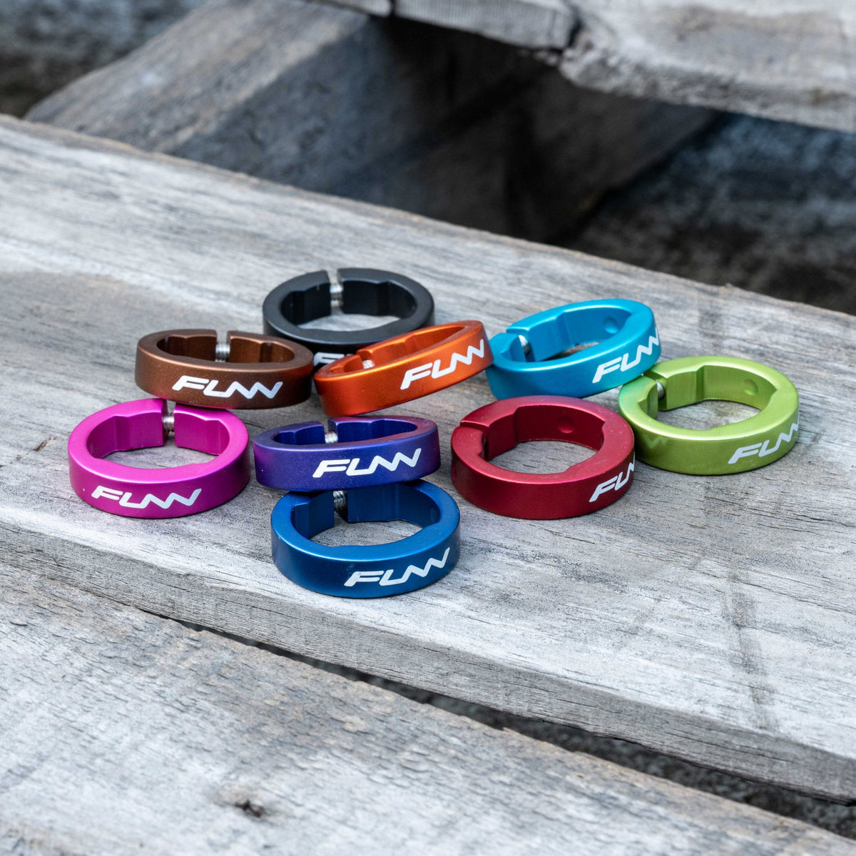 Colorful FUNN alloy bike grip clamping rings for Hilt / Holeshot, anodized metal lock rings laid on wooden surface