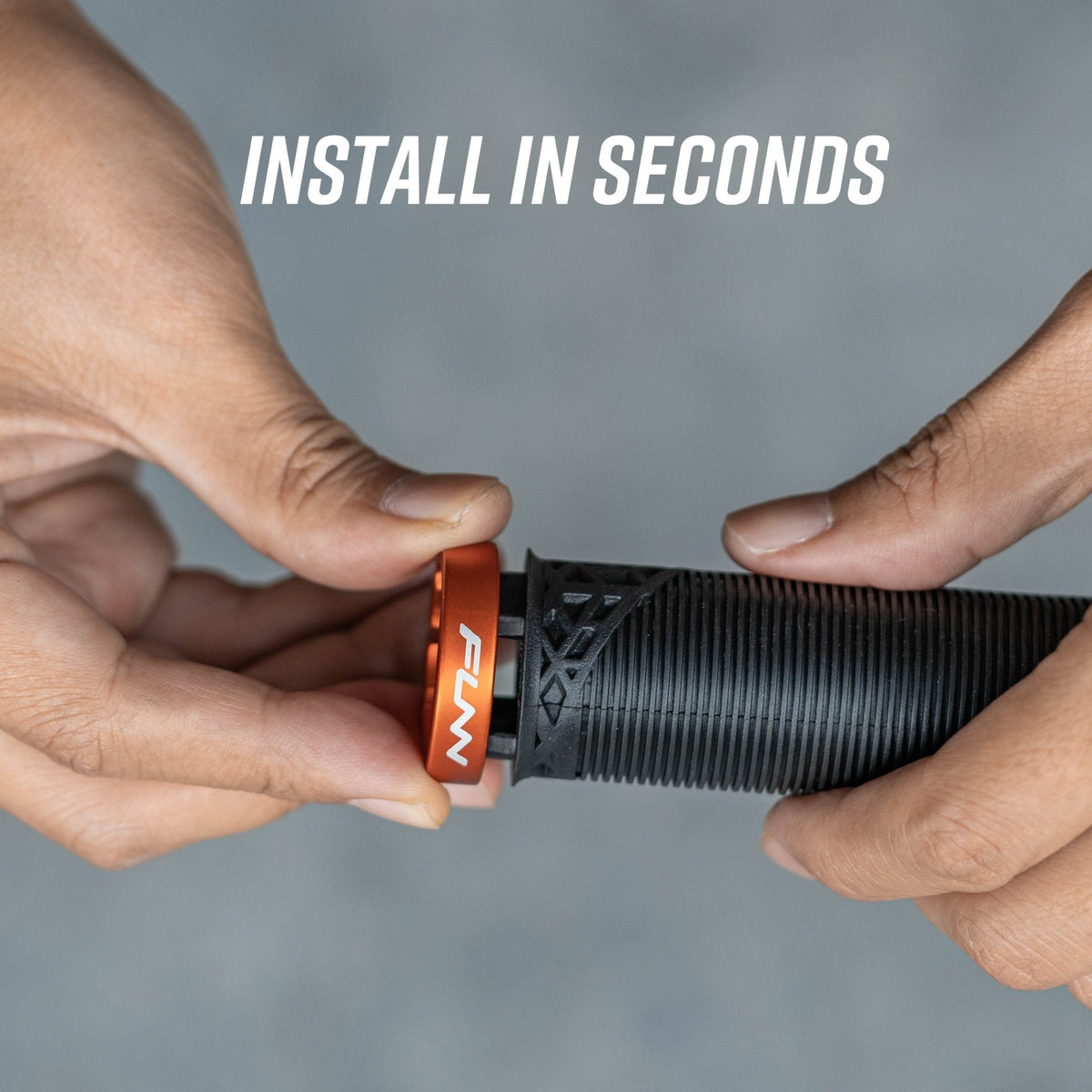 Hands installing orange FUNN alloy bike grip clamping ring onto black Hilt / Holeshot handlebar grip