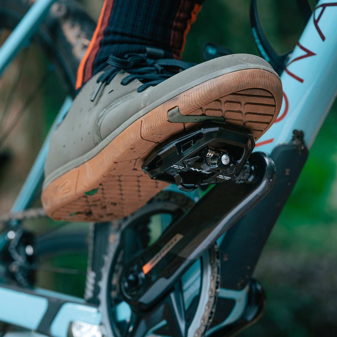 Rider’s shoe on black FUNN Clast Clip-In Pedals, combining flat pedal and SPD design on a mountain bike crank.