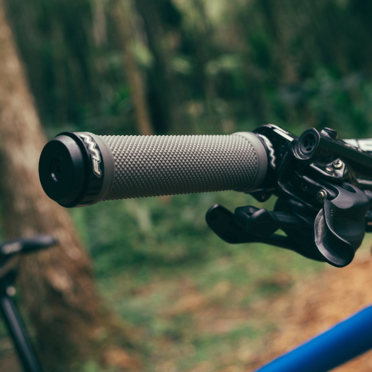 FUNN Combat I Lock-On Grips in grey rubber with textured pattern on mountain bike handlebar for secure trail control
