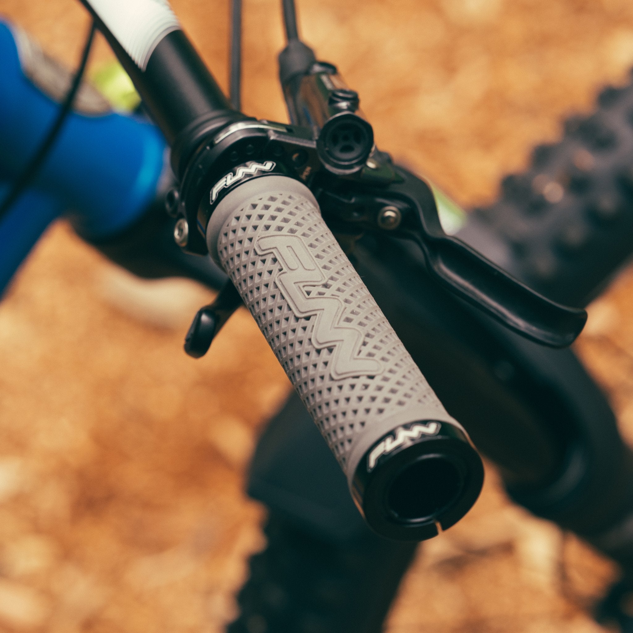 FUNN Combat II Lock-On Grips in grey rubber on mountain bike handlebar, textured pattern for secure, comfortable control