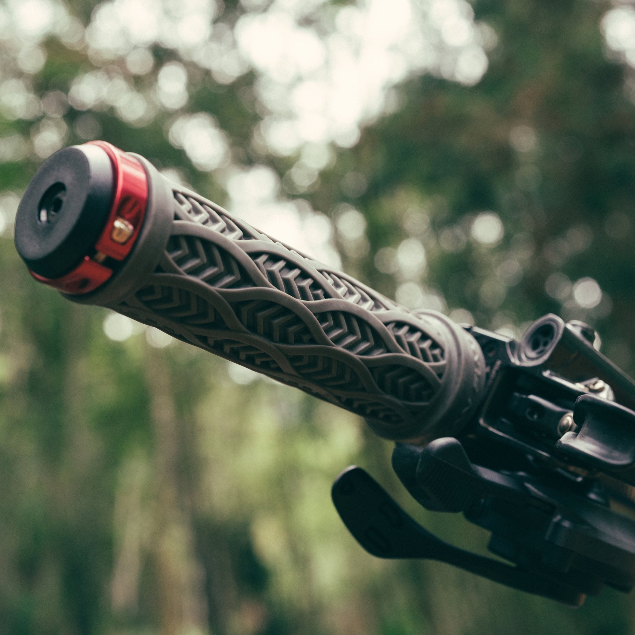 FUNN Combat III Lock-On Grips in gray rubber with textured pattern and red clamp, mounted on a mountain bike handlebar