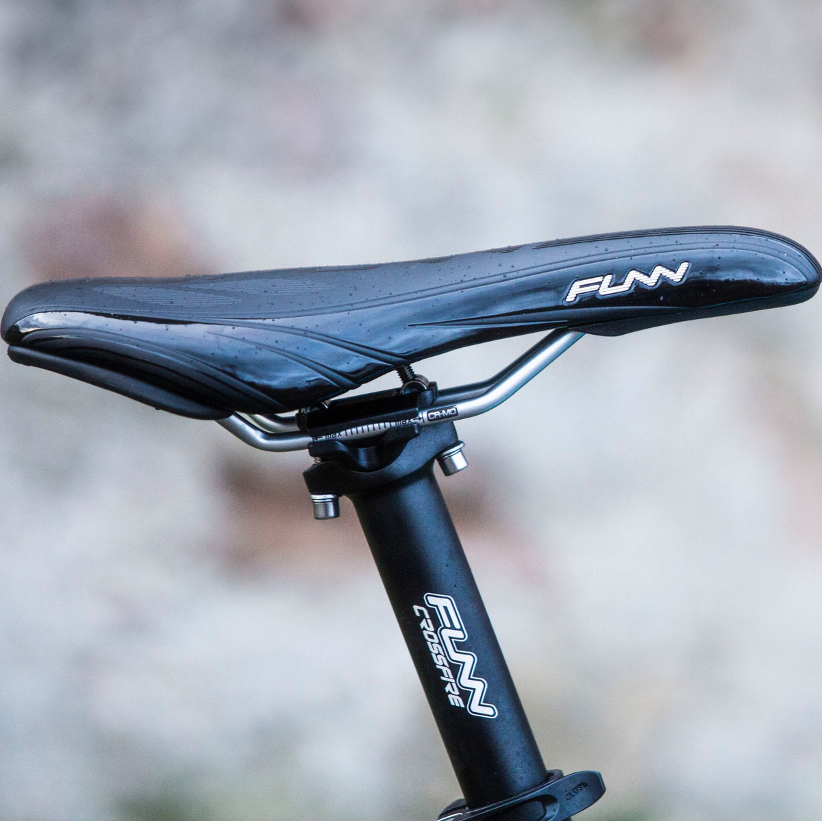 Black FUNN Crossfire Seatpost with sleek aluminum clamp supporting a wet black FUNN saddle, designed for durable MTB performance