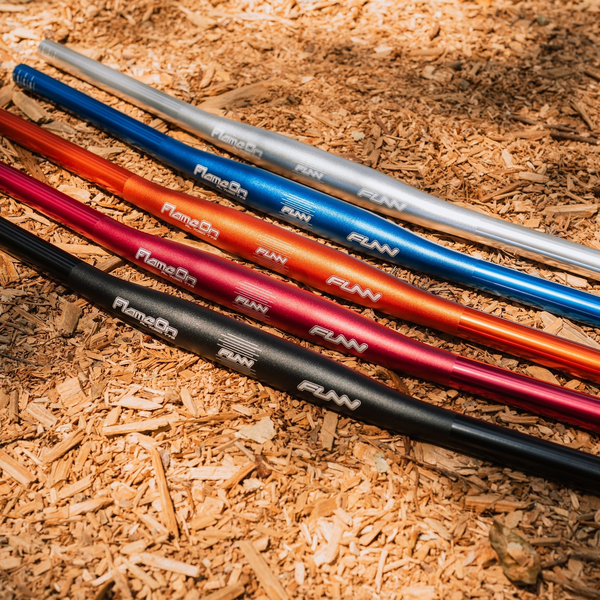 FUNN Flame On flat handlebars in black, red, orange, blue and silver alloy, lightweight MTB bars on trail surface