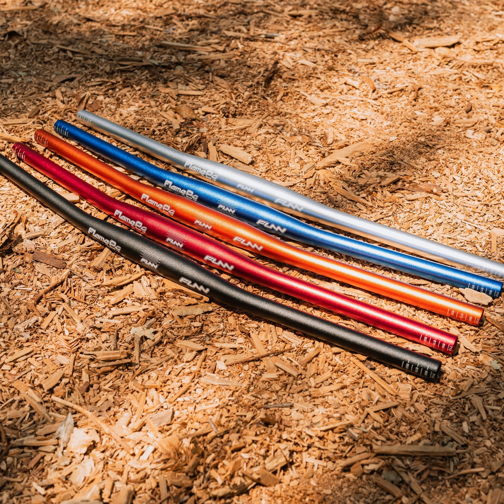 FUNN Flame Pg Flat Handlebar 710mm in multiple anodized alloy colors, lightweight MTB bar on trail surface