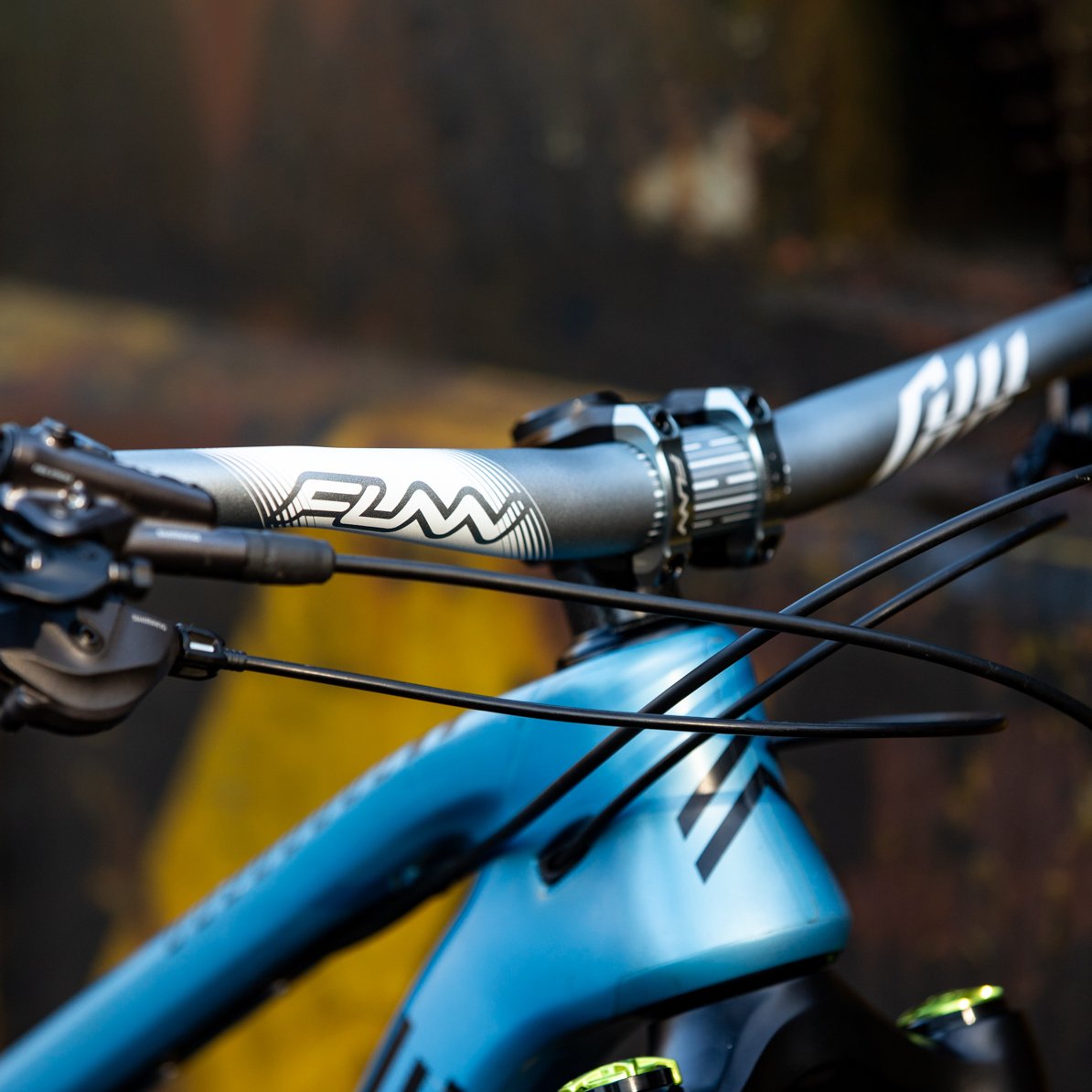 FUNN Full On Riser Handlebar, matte alloy MTB bar with white logos, mounted on blue trail bike for precise control