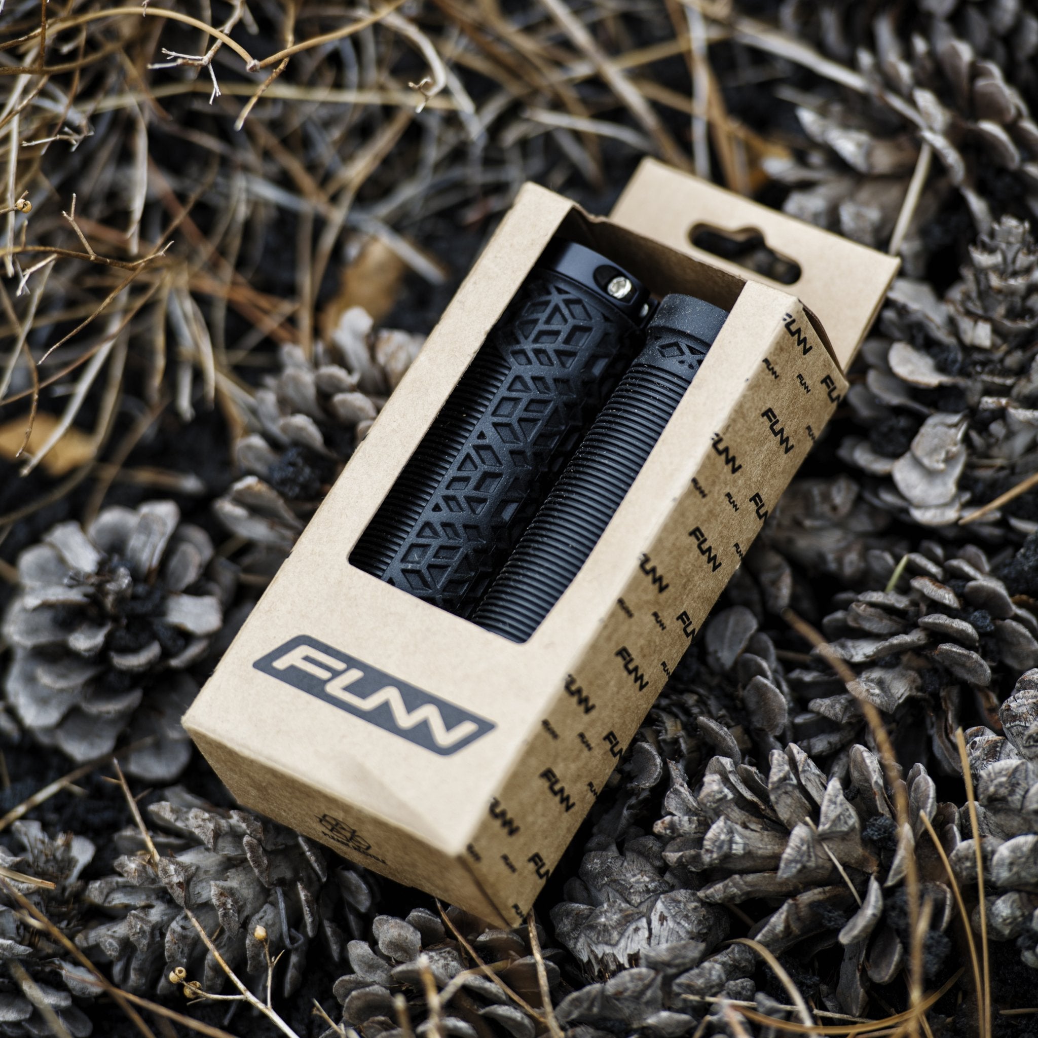 FUNN Hilt Lock-On Grips in black rubber with textured pattern, packaged in kraft box for secure mountain bike handlebar control