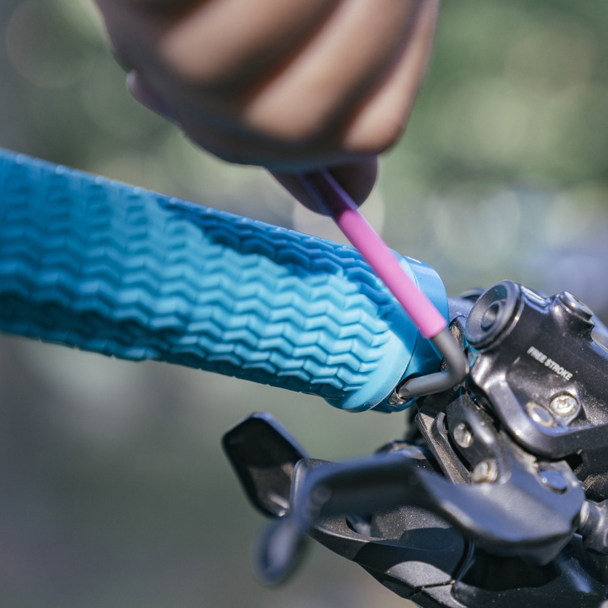 FUNN Holeshot Lock-On Grips, blue rubber single lock-on bike grips being tightened with hex key, easy for install