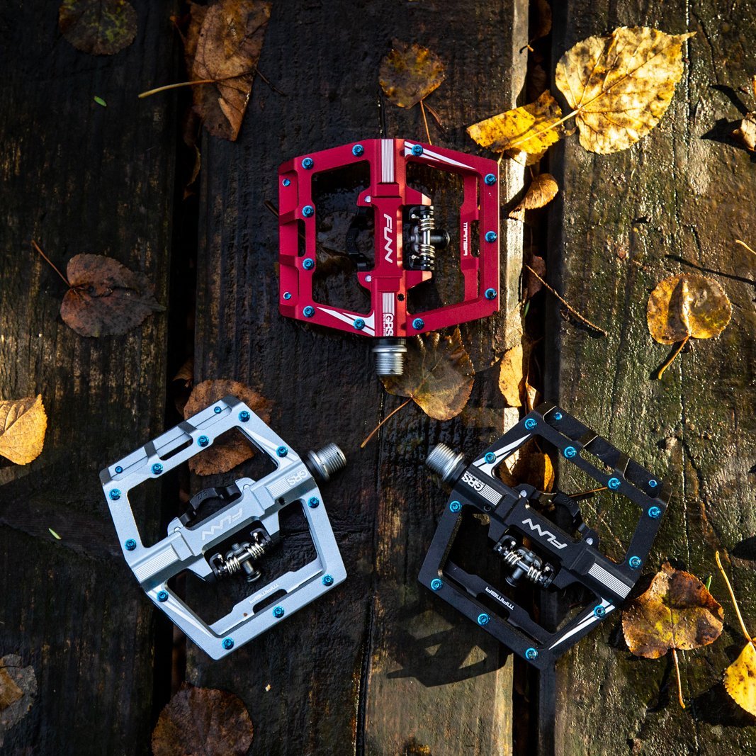 FUNN Mamba Clip-In Pedals, clip single side, red silver black alloy platforms with pins on rustic wood and autumn leaves