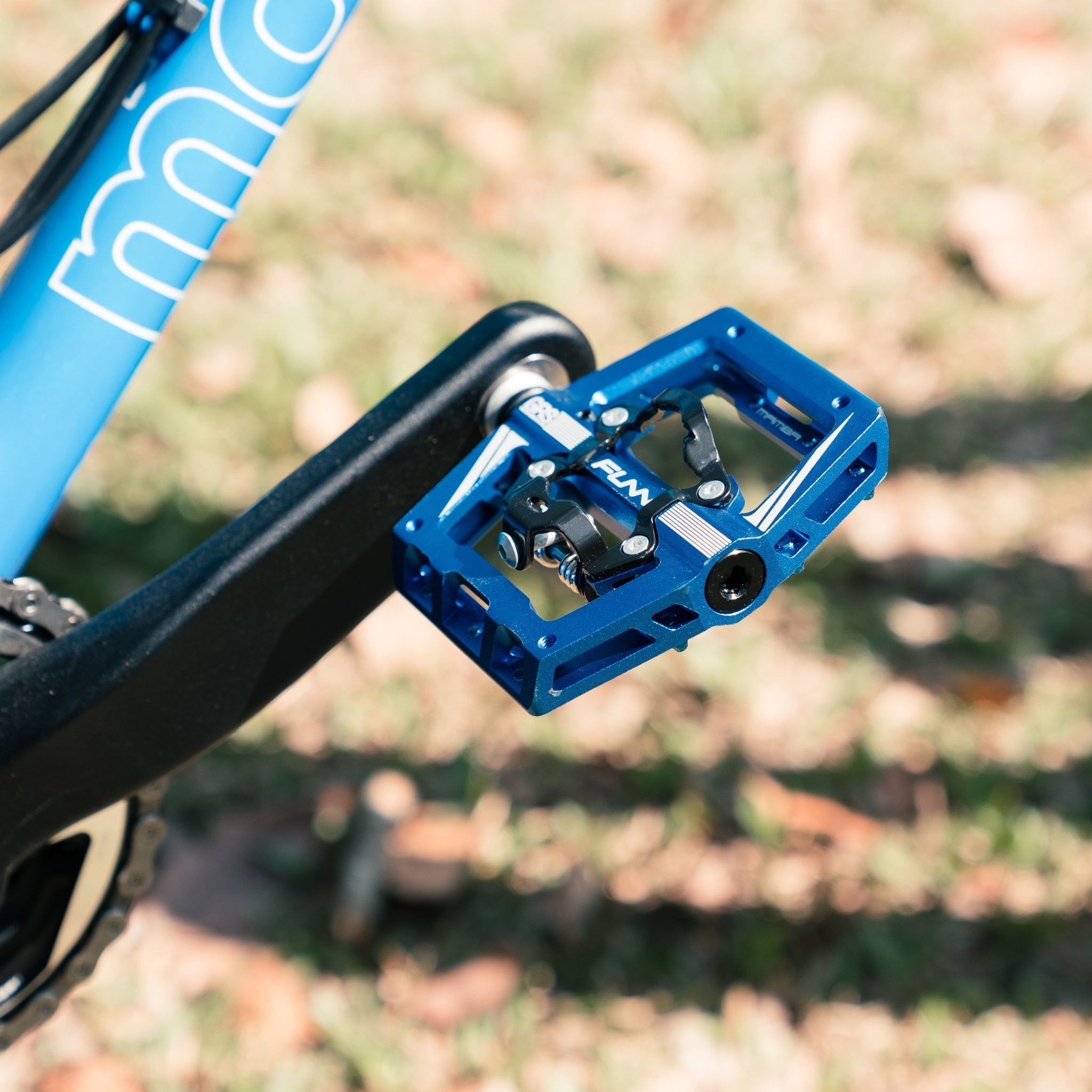 Blue aluminum FUNN Mamba S Clip-In Pedals with GRS system mounted on crank arm of a mountain bike outdoors