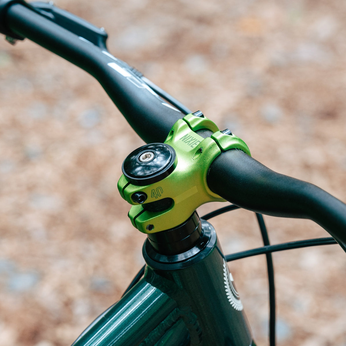 Green aluminum Nixie Stem by FUNN securely clamping black mountain bike handlebars on a trail-ready bike front end.