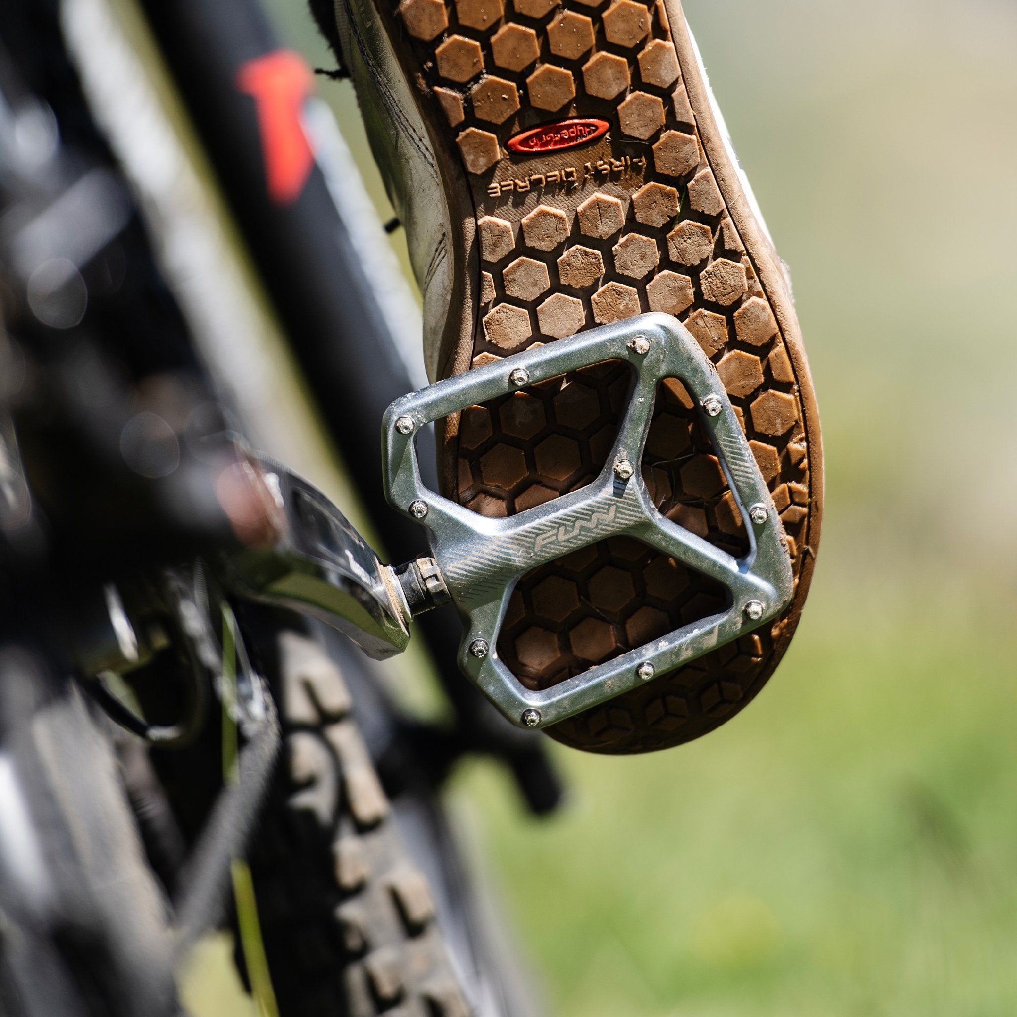 Funn Python flat pedals in grey alloy on mountain bike, wide platform with pins gripping hex-pattern sole for trail control