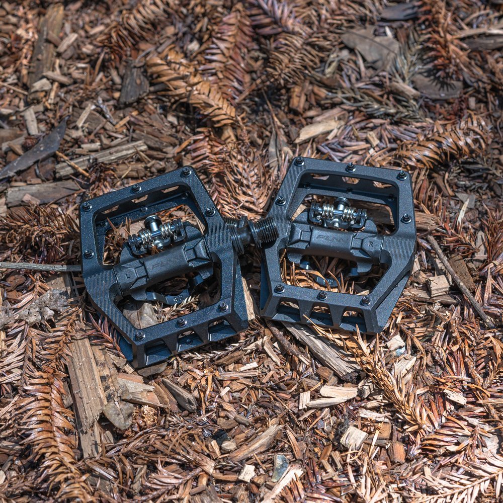Black FUNN Ripper2 MTB single side clip pedals with wide alloy platform and clip-in mechanism on forest trail ground
