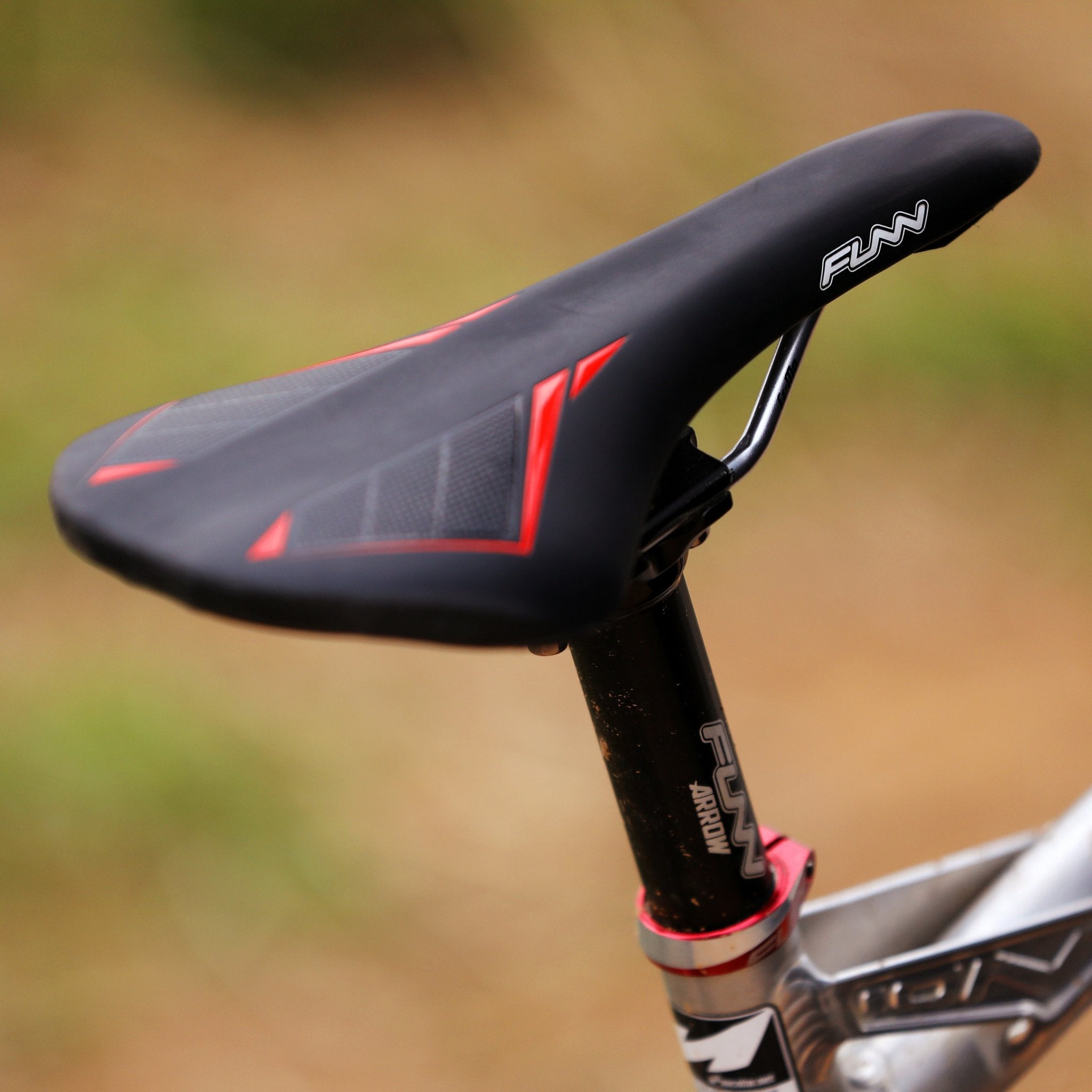 FUNN Skinny Saddle, slim black bike seat with red accents and padded surface, mounted on FUNN seatpost for MTB riding