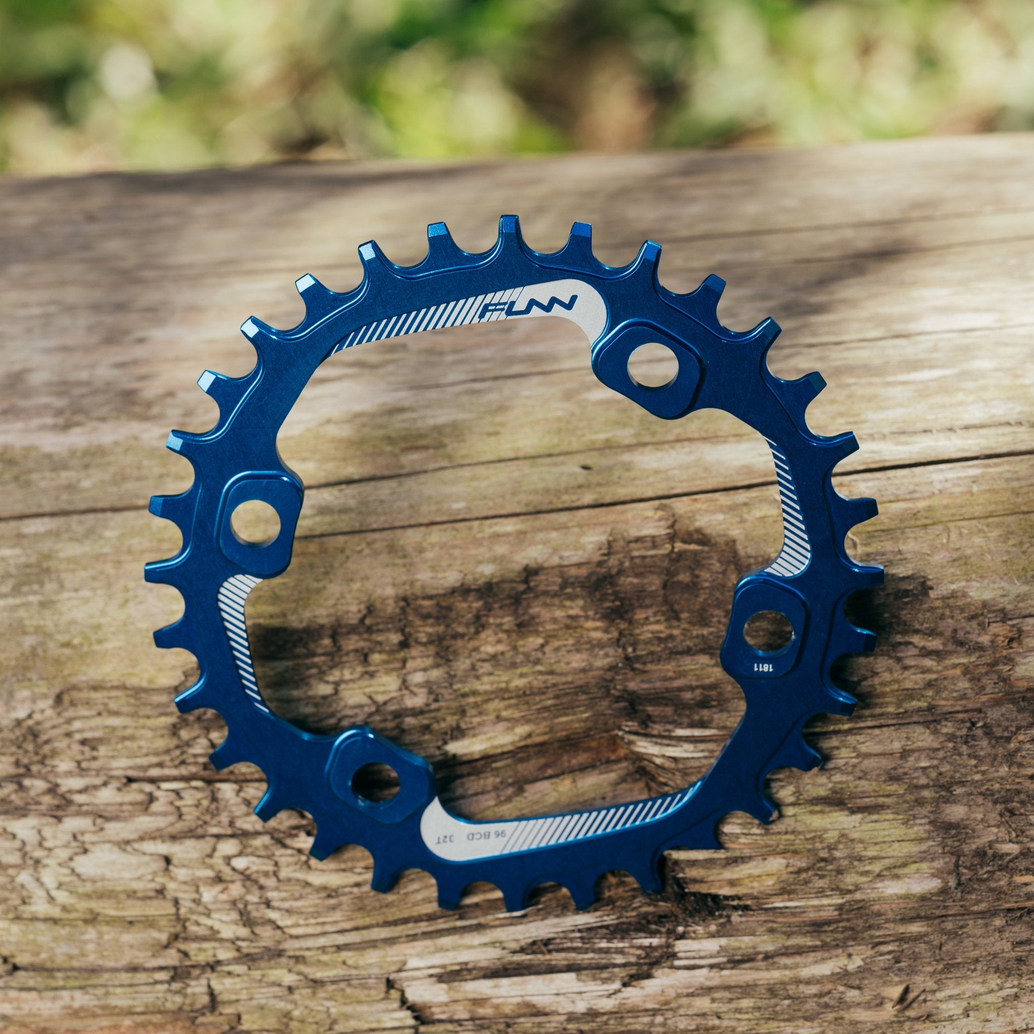 FUNN Solo 96 narrow-wide chainring, blue anodized alloy round bike sprocket for single-ring drivetrains on wooden surface
