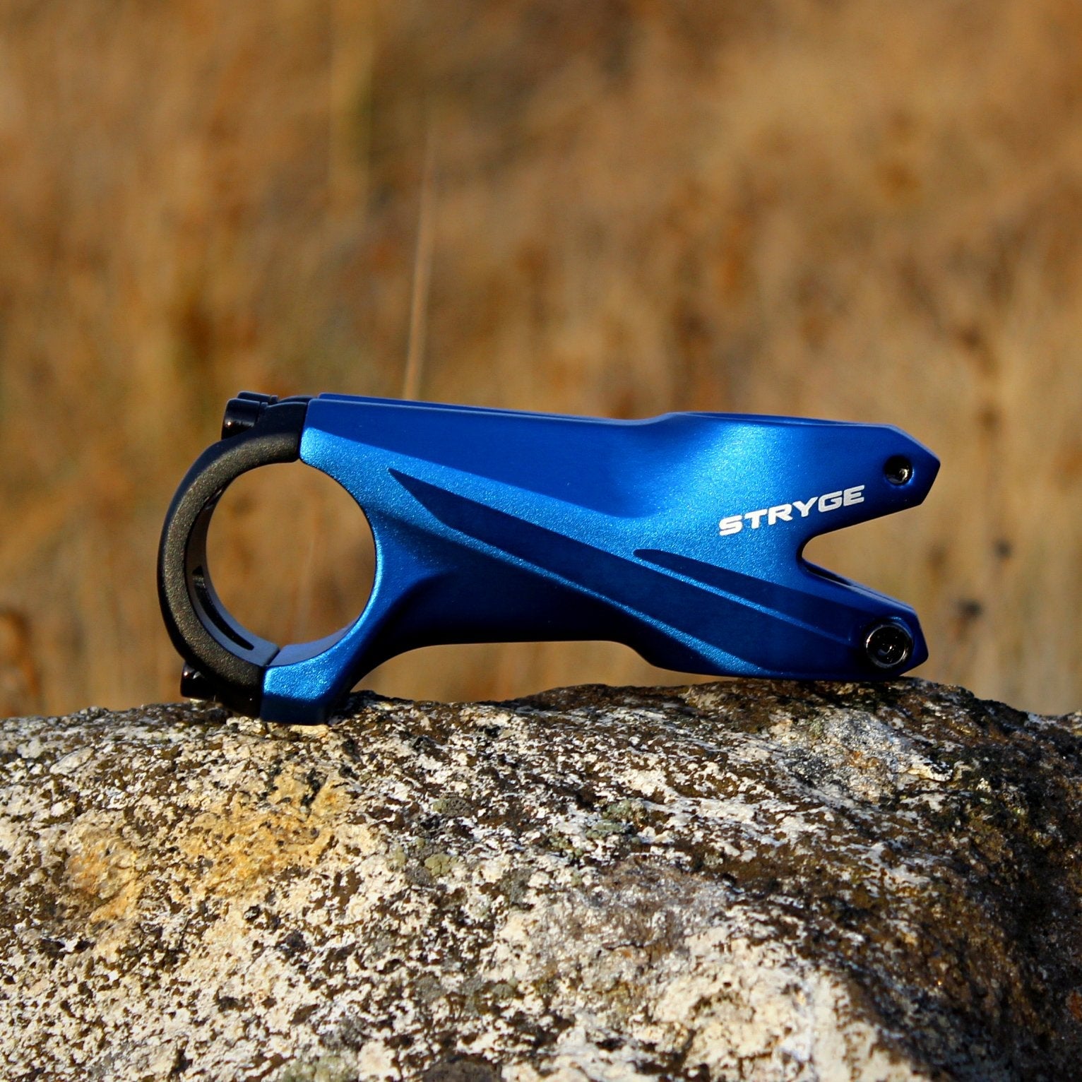 Blue aluminum Stryge Drop Stem by FUNN, low-profile bike handlebar stem with sleek aerodynamic design on rock background