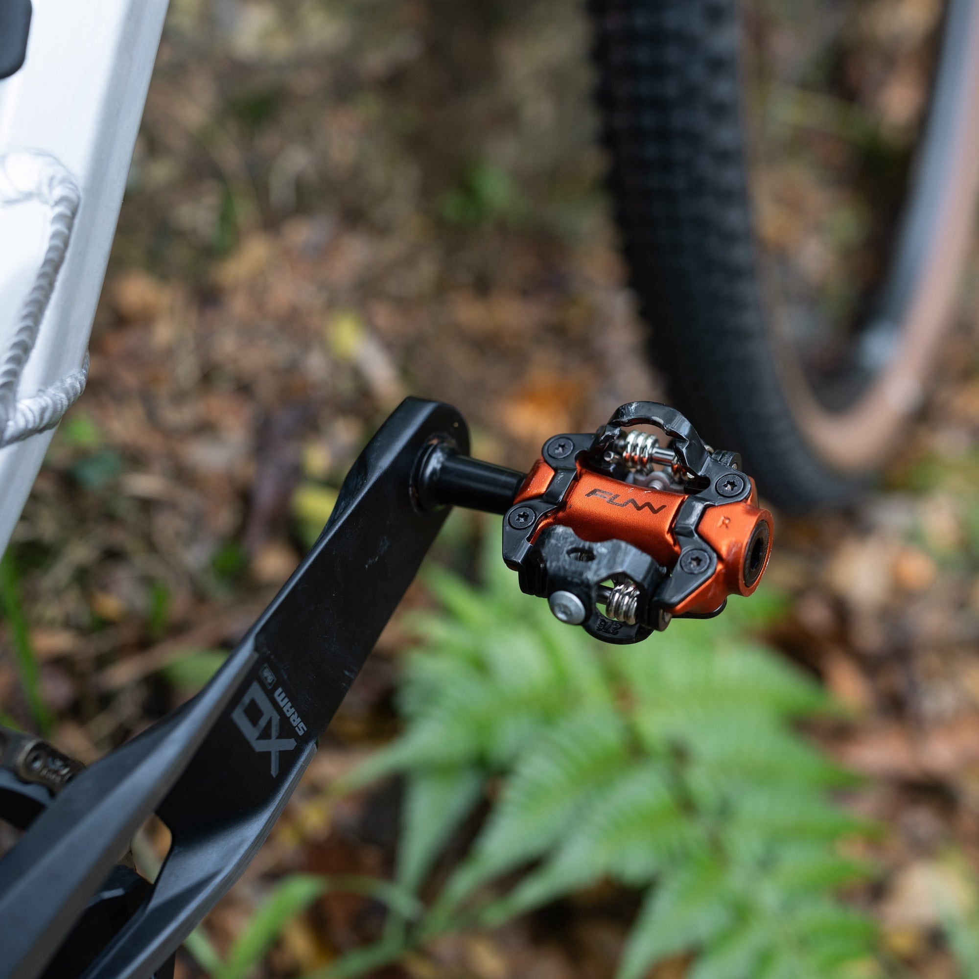 FUNN Tactic Clip-In Pedals in orange alloy on a mountain bike crank, low-profile SPD style for secure off-road riding