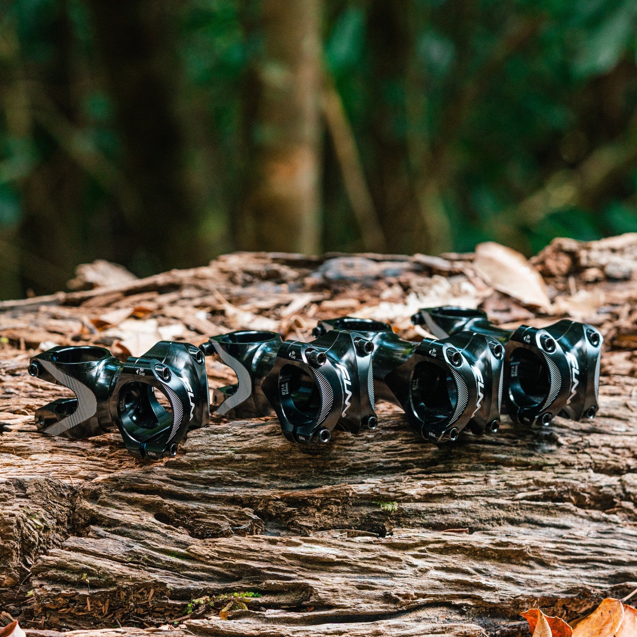 Tron Stem CNC aluminum black bike stems in multiple length options displayed on wood for mountain bike handlebars