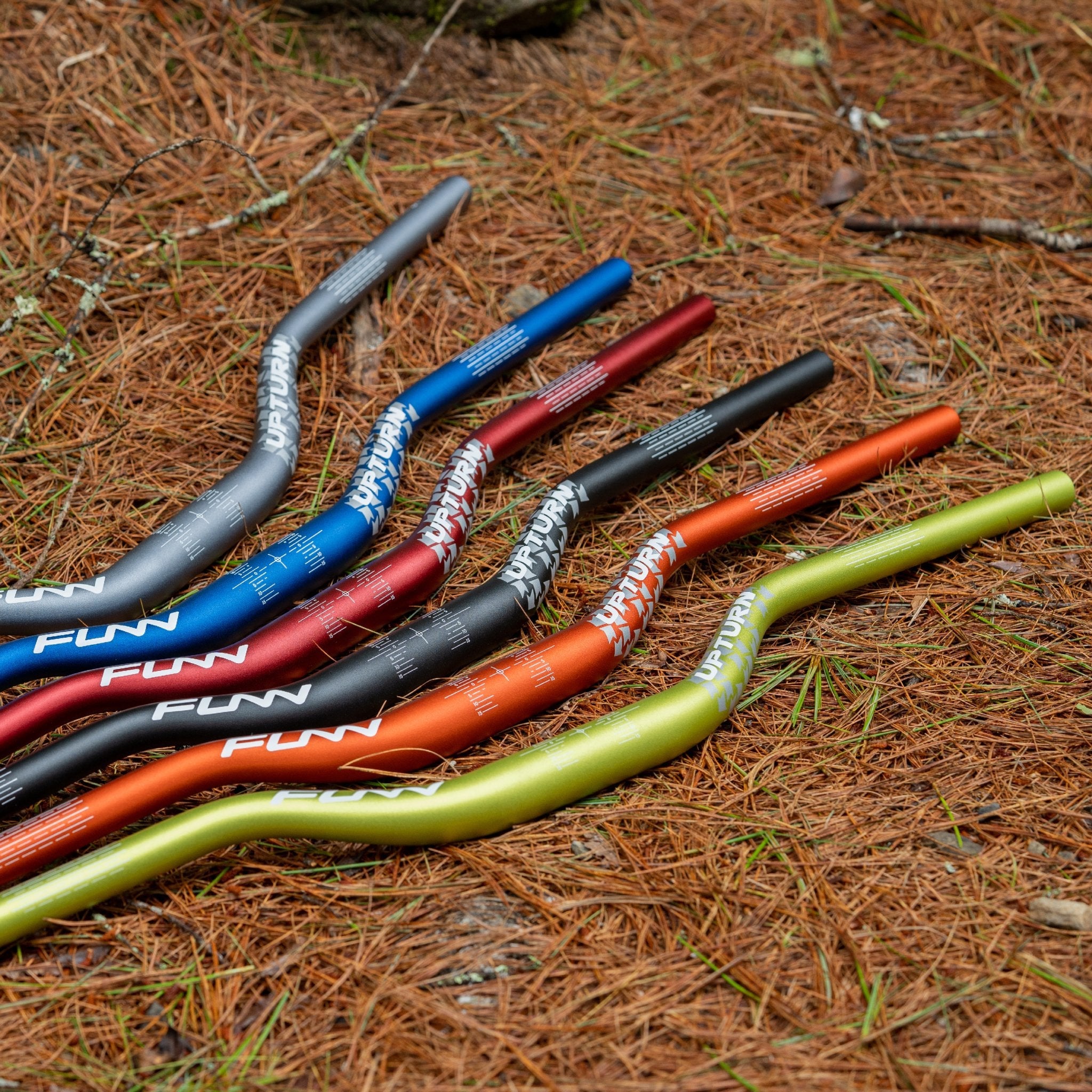FUNN Upturn High Riser Handlebar collection, colorful alloy mountain bike bars with high rise shape on forest trail floor