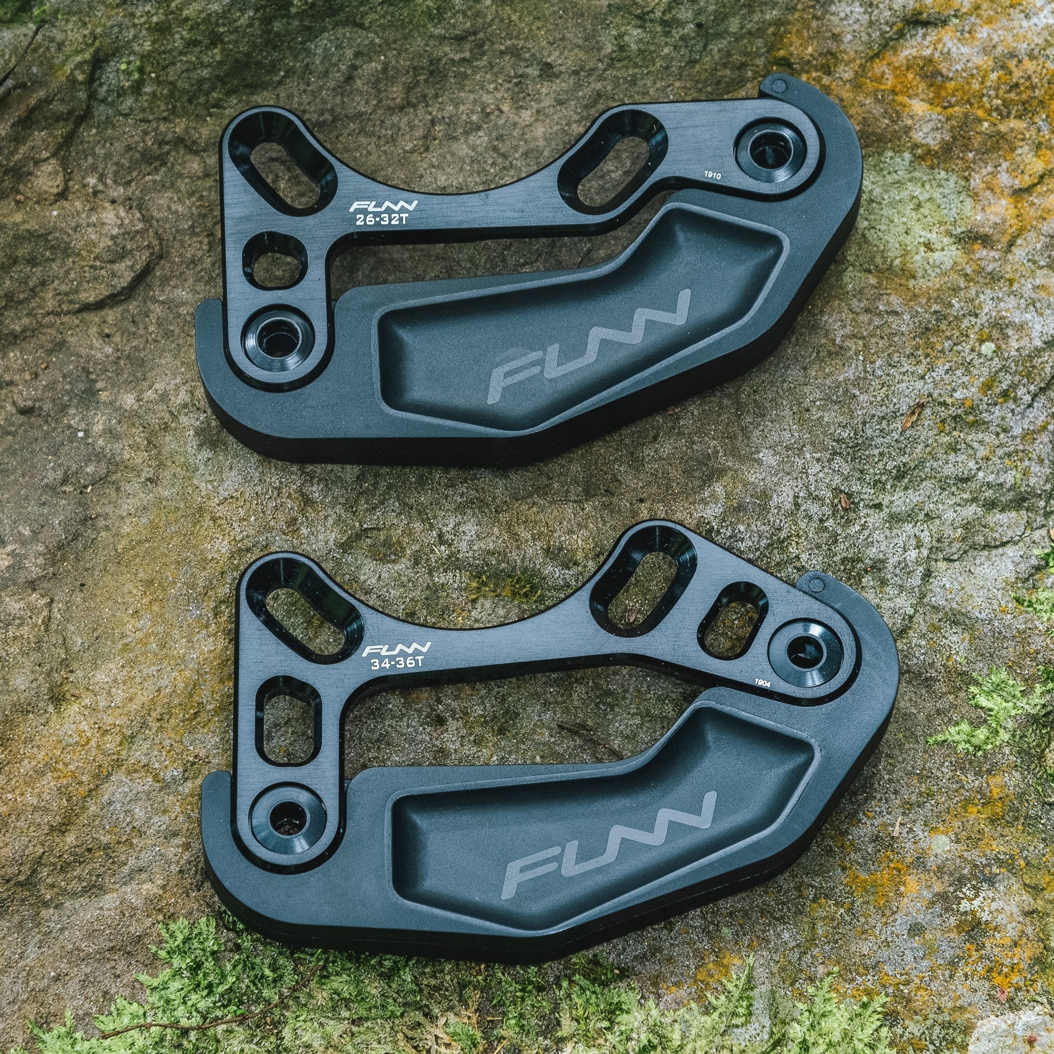 Black alloy FUNN Zippa Lite Bash Guard set for 26T–32T and 34T–36T chainrings, rugged MTB chainring protection on rock.