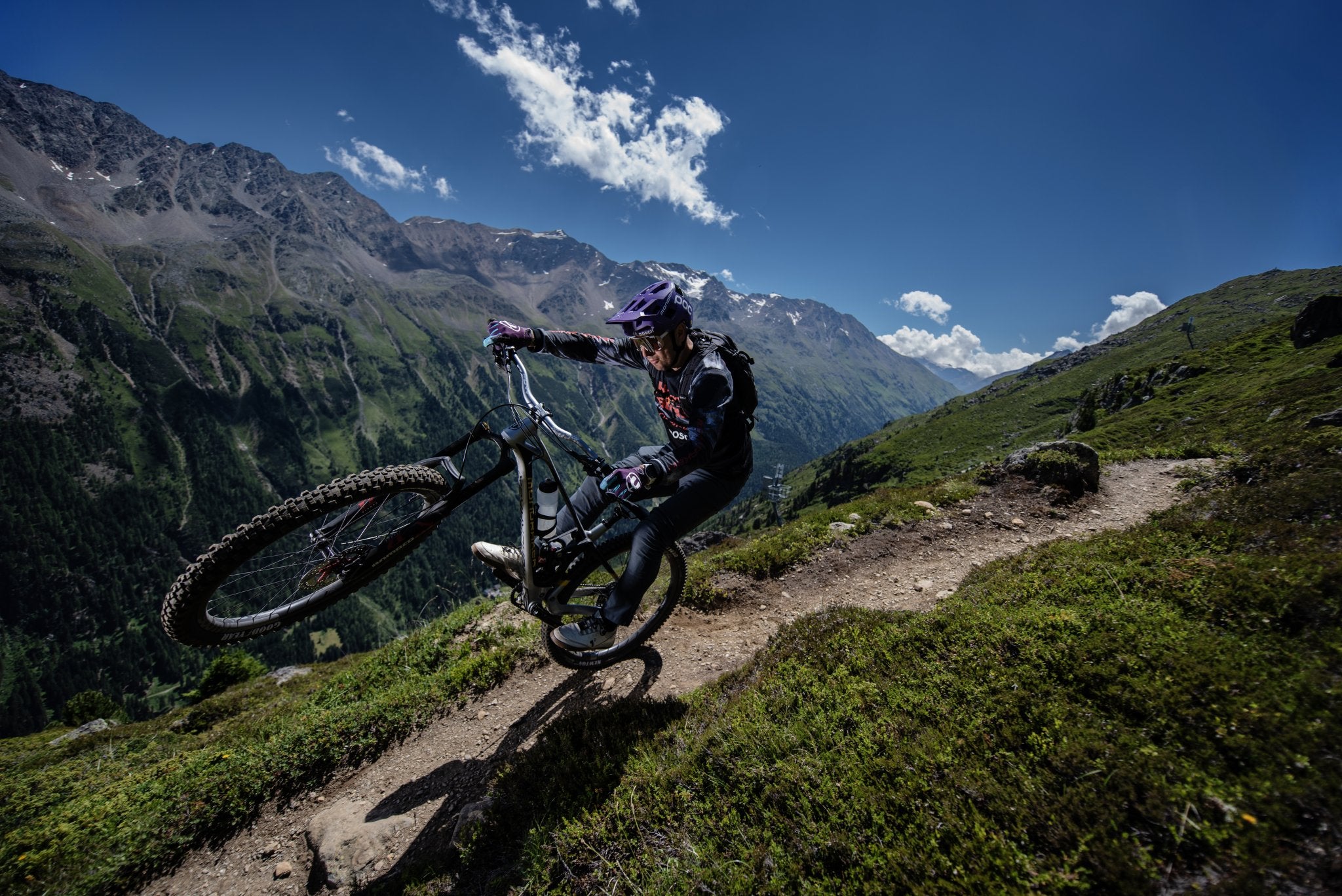 a rider is riding a mountain bike with funn upturn handlebar on the trail