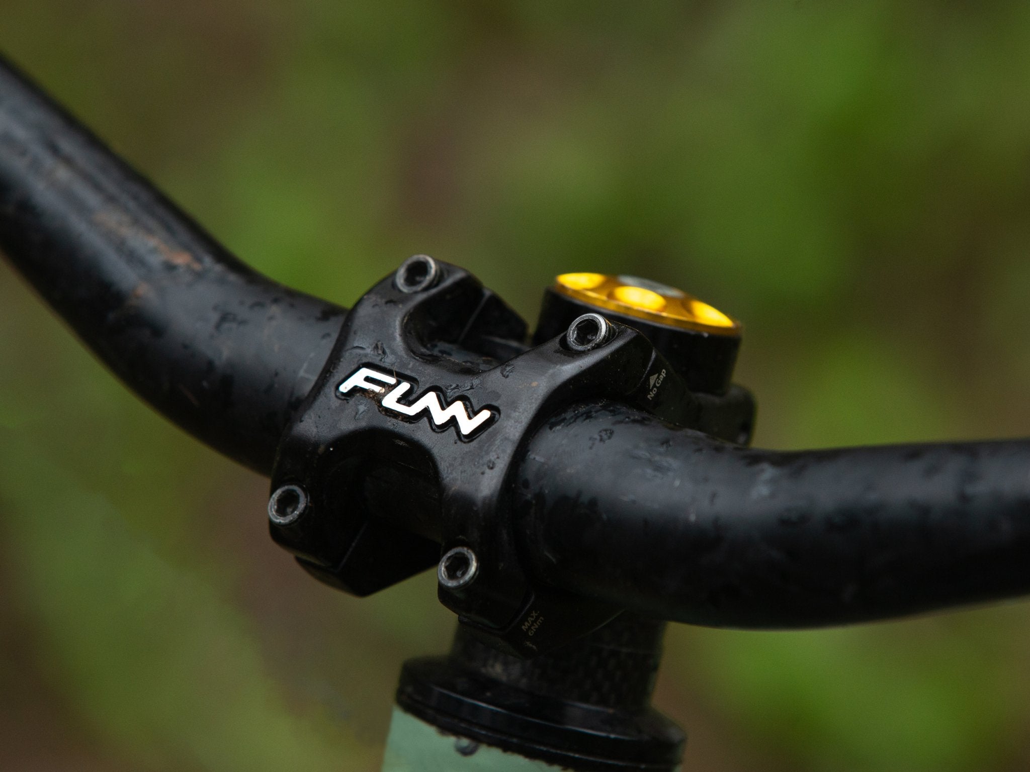 a mountain bike equipped with a black funn crossfire bike stem with some water drops in the outdoor