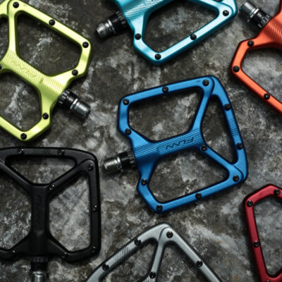 A group of colorful bicycle pedals on a concrete surface.