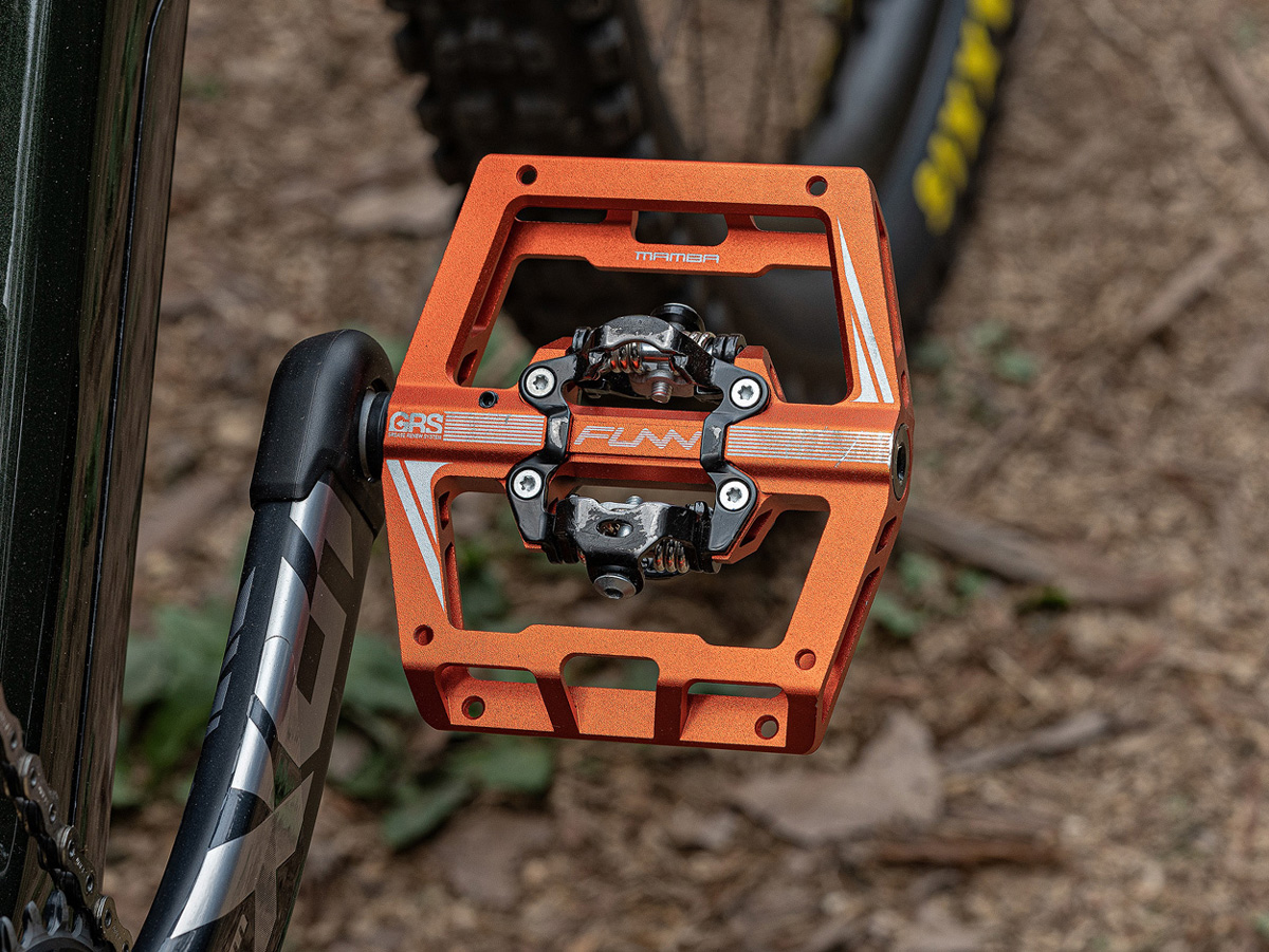 A bicycle with an orange mamba pedal attached to it.