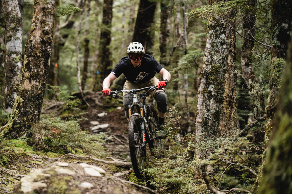 A man riding a mountain bike through a forest.