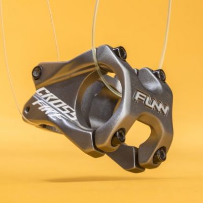 Funn Crossfire gray bike stem suspended mid-air, evoking a dynamic jump against yellow backdrop