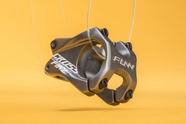 Funn Crossfire gray bike stem suspended mid-air, evoking a dynamic jump against yellow backdrop