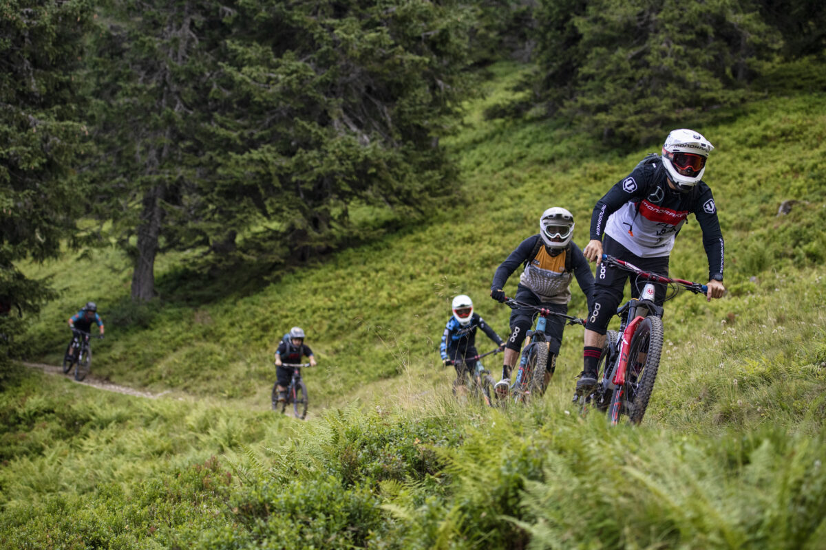 A group of mountain bikers riding down a trail.