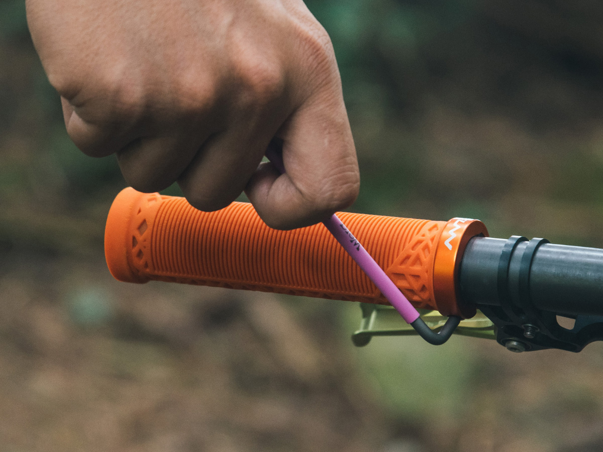 tighten the bolt of a orange hilt single lock on bike grip